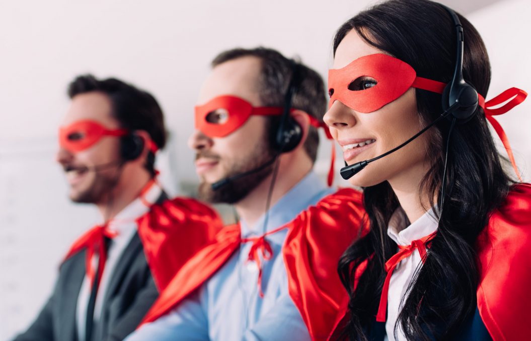 super businesspeople in masks and headsets supporting customers in call center